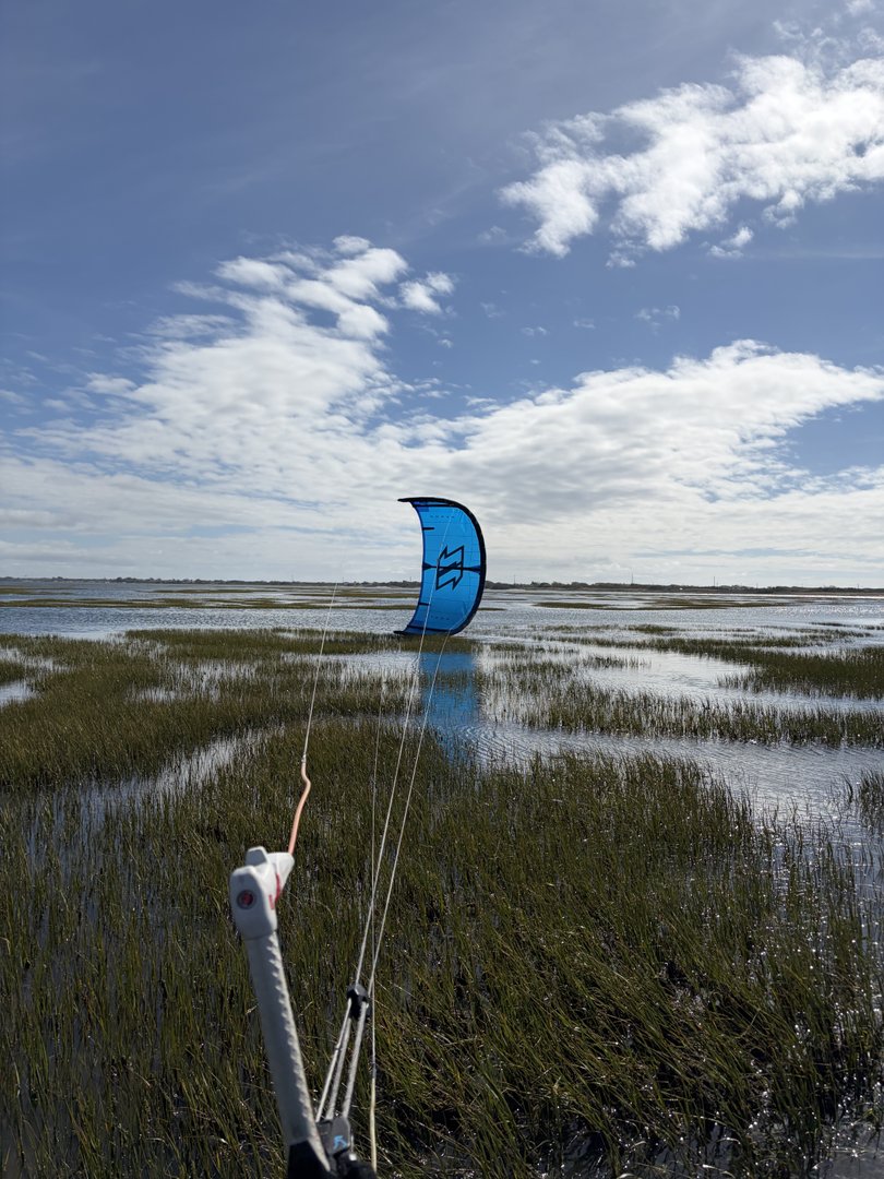 Vista de kites sobre el agua plana de Ervas en una marea entrante