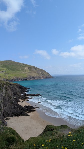 An aerial view of Coumeenole beach with waves breaking on the shore and cliffs rising above. — Coumeenole (Dunquin), Dunquin, Kenmare Municipal District, Ireland