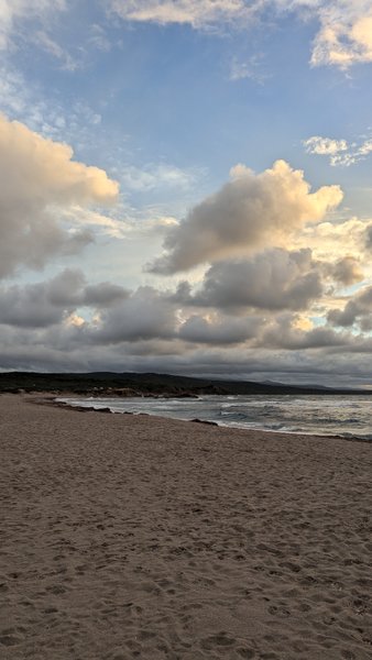 A wide view of the sandy beach and surf at Rena Majore under a cloudy sky. — Rena Majore (Sardenha), Aglientu, Sardinia, Italy