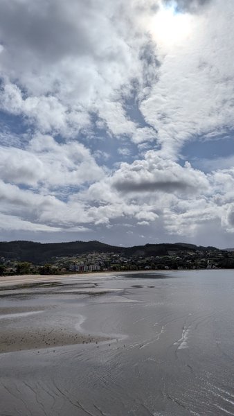 A wide view of Cedeira bay at low tide, with the town and hills in the background under a cloudy sky. — Cedeira (Valdoviño), Cedeira, Galicia, Spain