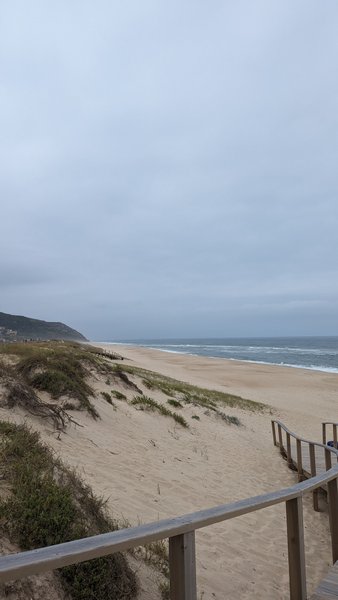 A wide sandy beach with dunes and a wooden boardwalk under an overcast sky. — Murtinheira (Beira), Figueira da Foz, Portugal