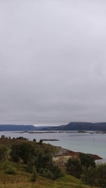 A coastal landscape view of Hillesøy with islands and mountains under an overcast sky. — Hillesøy (Skipholmen), Tromsø, Norway