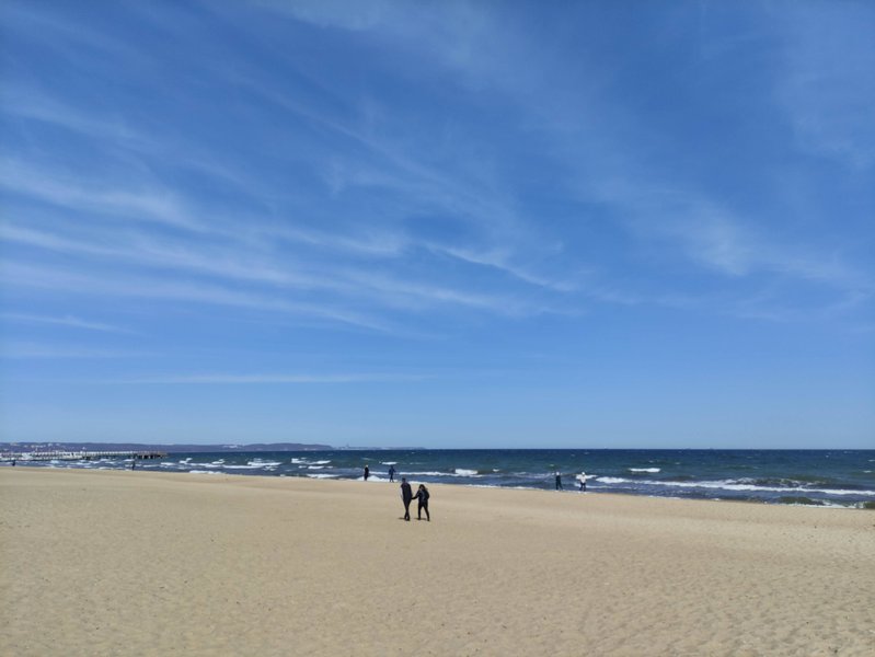 A wide sandy beach under a blue sky at the Gdańsk spot.