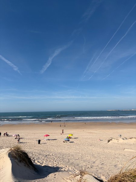 A wide view of the sandy beach and ocean at Praia do Cerro.