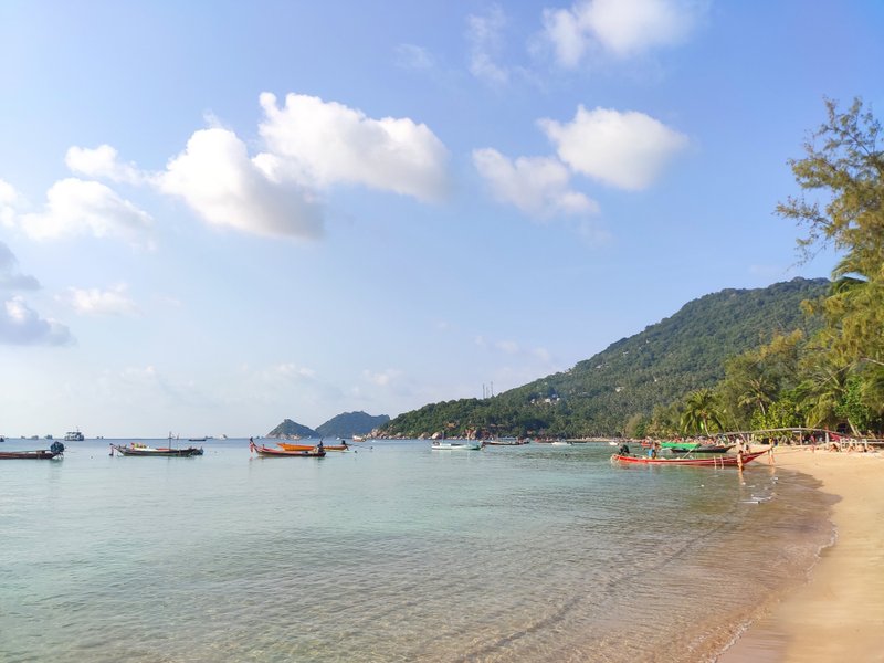 A view of Sairee Beach with long-tail boats and clear waters under a blue sky. — Plage de Sairee (Ko Tao), Ko Pha-ngan District, Thailand