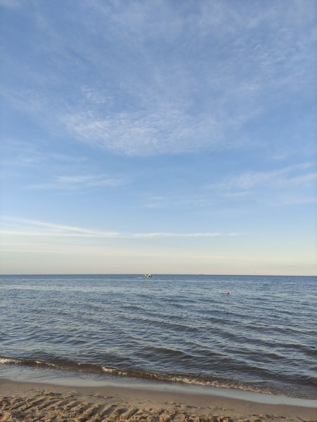 A view of the Baltic Sea and sandy beach at Sopot under a clear sky.