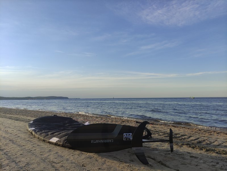 Kite foiling gear on the sandy beach at Sopot overlooking the water.