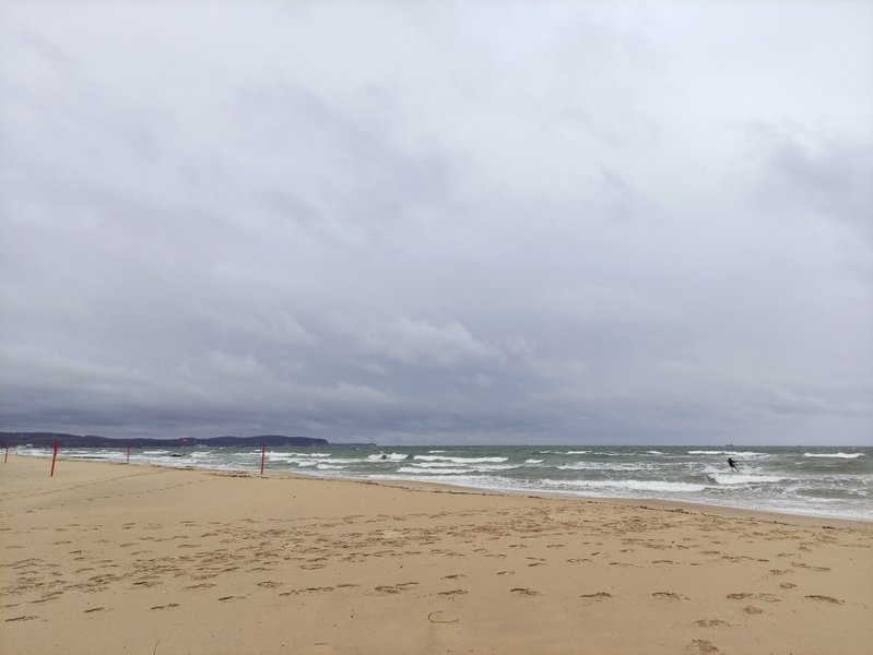 Wide view of Sopot beach and the Baltic Sea under cloudy skies.