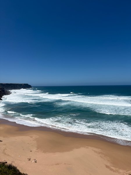 A high-angle view of the beach and waves at Telheiro Beach under a clear blue sky. — Praia do Telheiro (Sagres), Sagres, Portugal