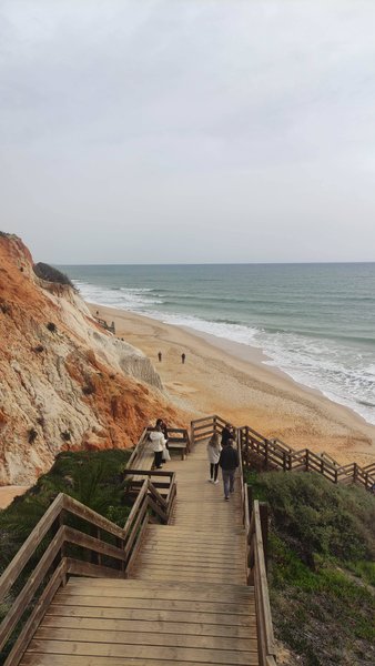 A wooden staircase leads down to the beach at Albufeira, showing the coastline and cliffs. — Albufeira (Faro), Albufeira, Portugal