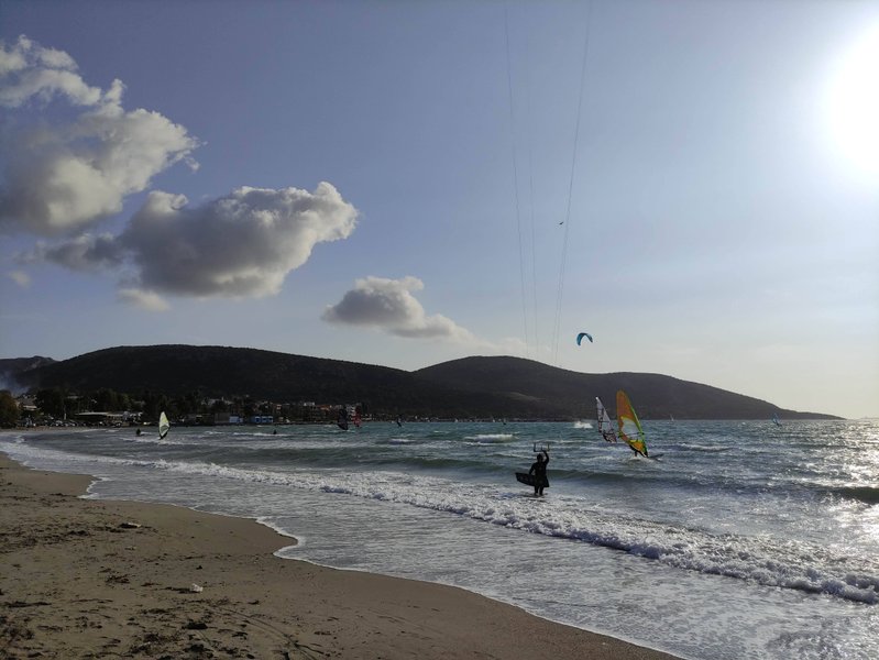 Windsurfers and a kitesurfer on the water at Anavissos beach.