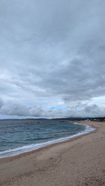 A wide view of the beach and water at Vignola Mare with a kite surfer in the distance. — Vignola Mare (Sardenha), Baia Vignola, Sardinia, Italy