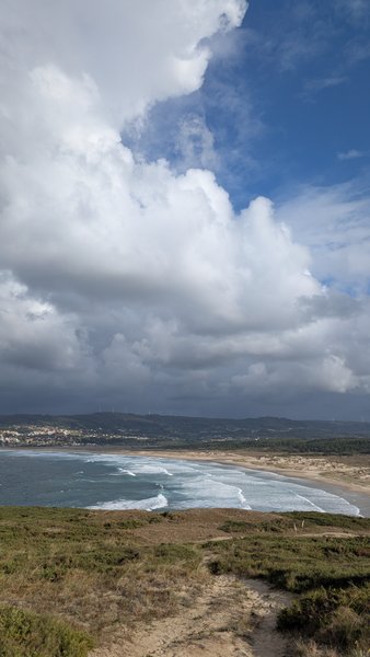 An elevated view of Valdoviño beach with breaking waves and dramatic clouds above the coast. — Valdoviño (Da Frouxeira), Valdoviño, Galicia, Spain