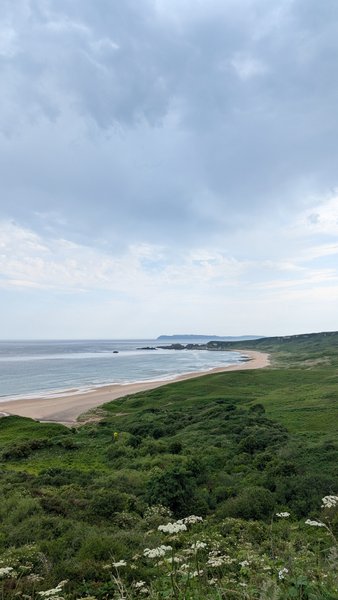 A wide elevated view of White Park Bay showing the sandy beach and coastline.