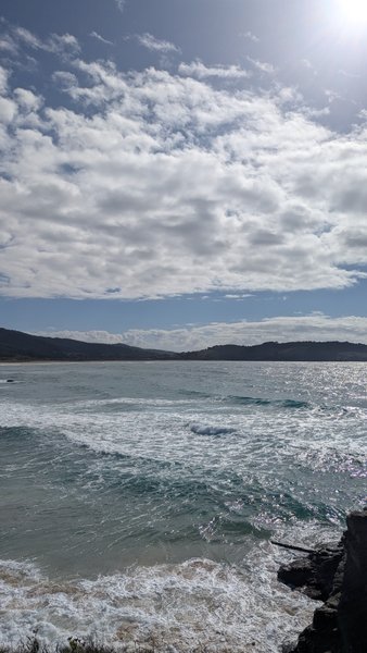 A wide view of the bay at Cobas with waves breaking near the shore under a cloudy sky. — Cobas (Ferrol), O Porto, Galicia, Spain