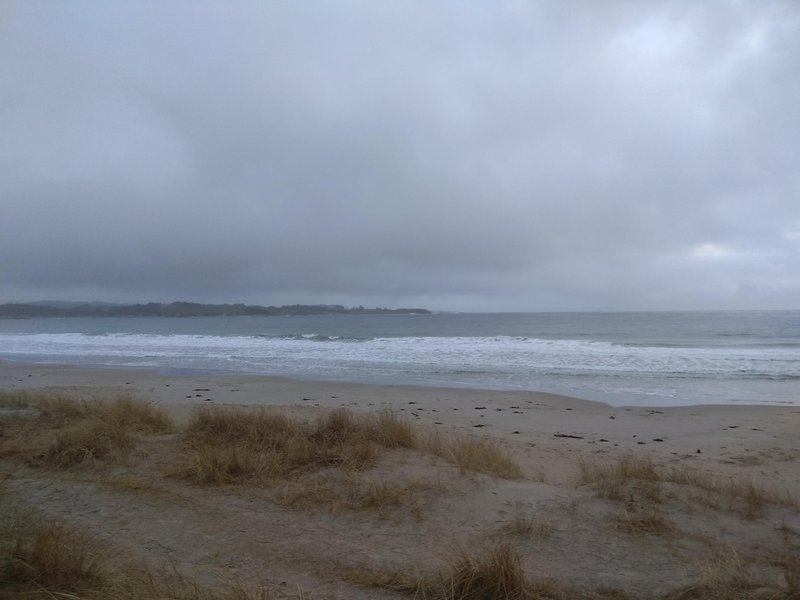 A view across the sand dunes towards the waves at Solastranden under a cloudy sky. — Solastranden (Sola Coast), Sola, Norway