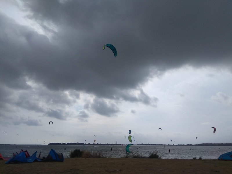 Numerous kitesurfers on the water at Lo Stagnone under a moody, overcast sky. — Lo Stagnone (Marsala), Marsala, Sicily, Italy