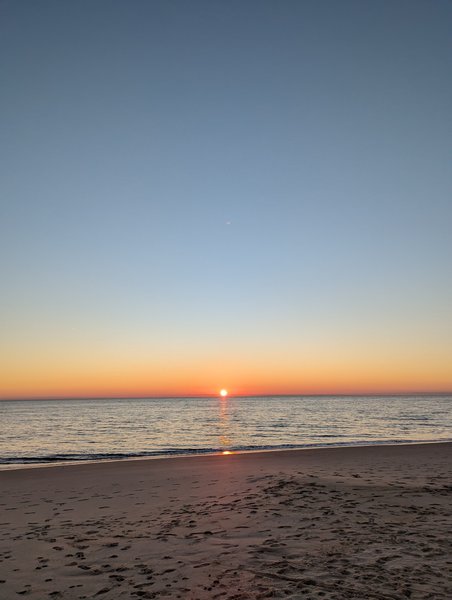 A clear view of the sunset over the sandy beach and calm water at Matalascañas. — Matalascañas (Costa de El Condado), Almonte, Andalusia, Spain