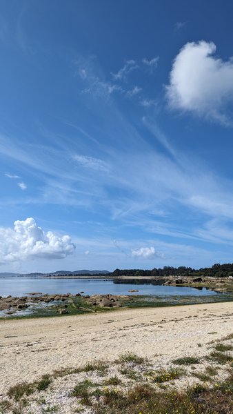 A scenic view of the beach and calm bay at A Illa de Arousa.