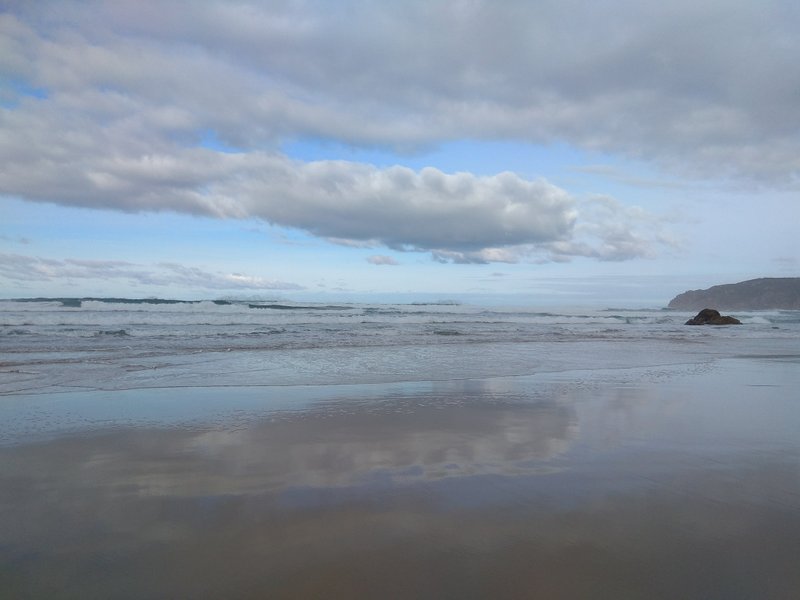 Wide landscape of Praia do Guincho showing the beach, waves, and sky reflections. — Praia do Guincho (Cascais), Cascais, Portugal