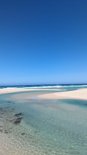 Clear shallow waters and beach at Playa de Baldaio under a bright blue sky. — Praia de Baldaio (Bergantiños), A Pedra do Sal, Galicia, Spain