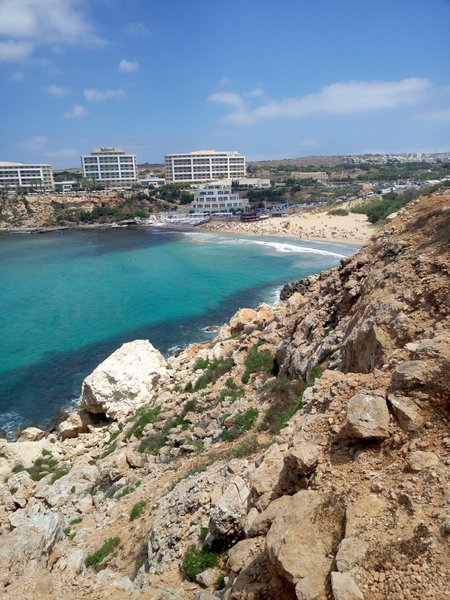 An elevated view of Golden Bay showing the beach, riding area, and shorefront buildings. — Golden Bay (Manikata), Manikata, Malta