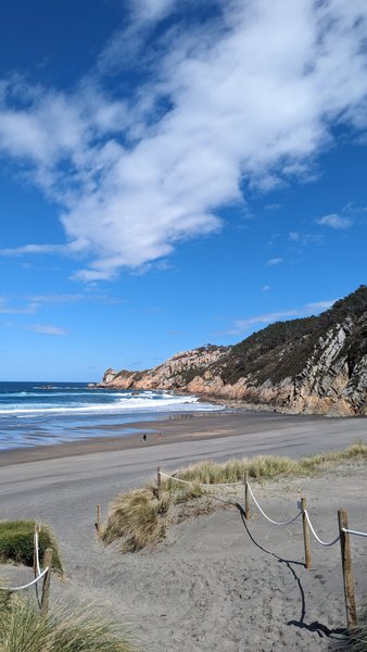 A wide view of Playa de Barrayo showing the sandy beach, breaking waves, and surrounding cliffs. — Playa de Barrayo (Otur), Valdés, Asturias, Spain