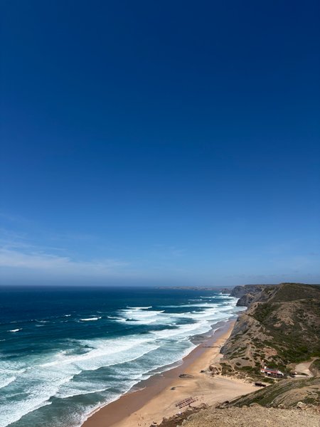 A high-angle view of Cordoama beach showing the coastline and rolling waves.