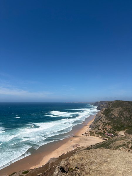 A wide landscape view of Cordoama beach, showcasing the coastline and surf conditions.