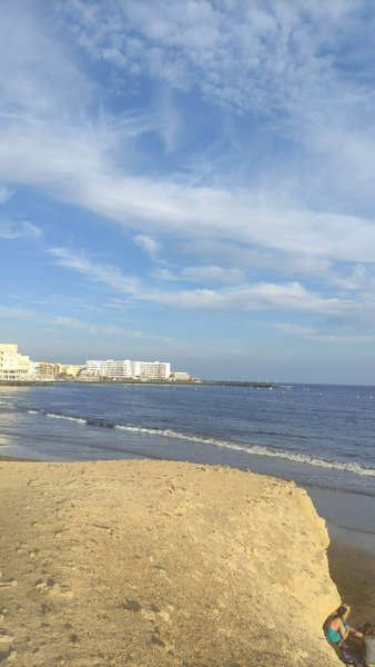 View of the beach and water at El Médano with buildings in the background. — El Médano (Flashpoint Beach), Granadilla de Abona, Canary Islands, Spain