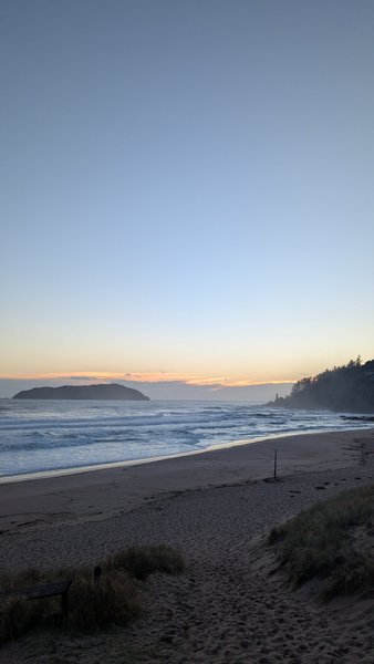 A wide landscape view of Tairua Beach at dusk showing the waves and the offshore island. — Playa de Tairua, Tairua, Waikato, New Zealand