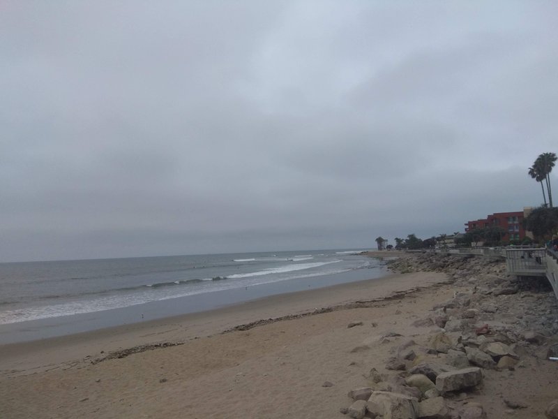 A wide view of the sandy beach and ocean waves under a cloudy sky. — San Buenaventura State Beach, Ventura, California, United States