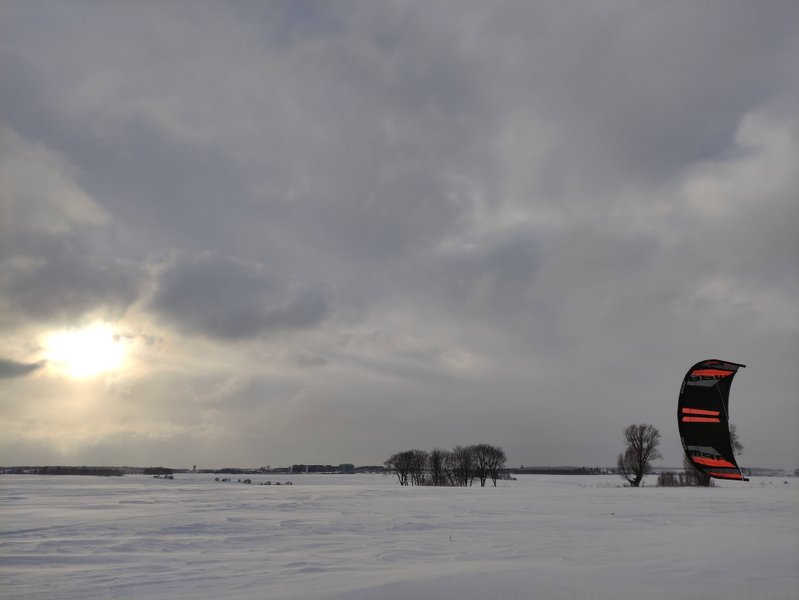 A lone kite flies over the snowy fields of Barniewice.