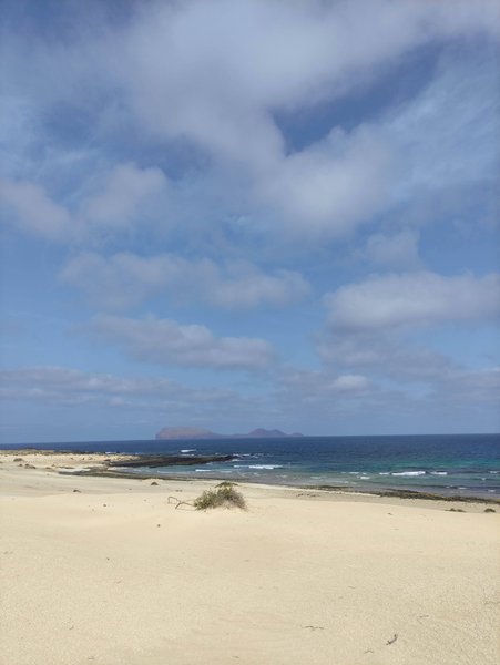 A wide view of the sandy dunes and coastline at Playa Lambra with an island in the distance. — Playa Lambra (La Graciosa), Teguise, Canary Islands, Spain