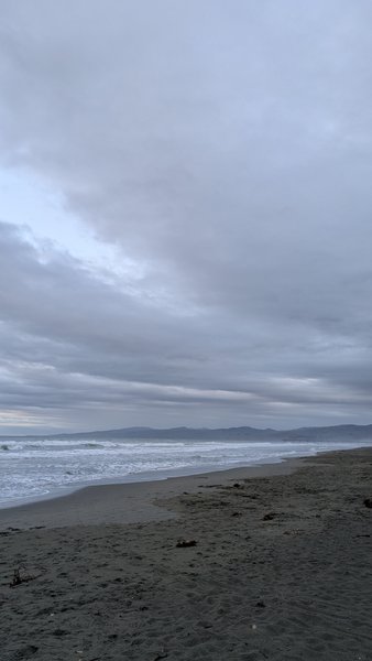 A wide view of New Brighton North beach under a cloudy sky. — New Brighton Norte (Christchurch), Coastal-Burwood Community, Canterbury, New Zealand