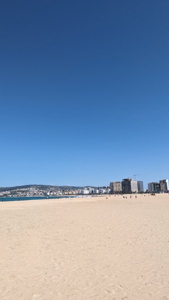 A wide view of the sandy beach in Tangier with the city skyline in the background. — Tangier (Strait of Gibraltar Coast), Tangier, Morocco