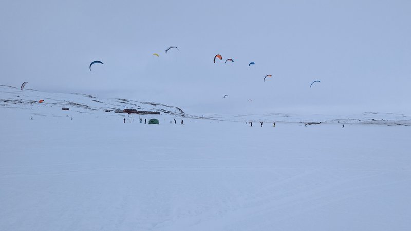 Several snowkiters on the white expanse of the Hardangervidda plateau near Fagerheim. — Fagerheim (planalto de Hardangervidda), Norway