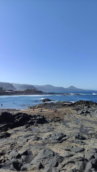Rocky coastline and ocean at Los Enanos with mountains in the background. — Los Enanos (Moya), Arucas, Canary Islands, Spain