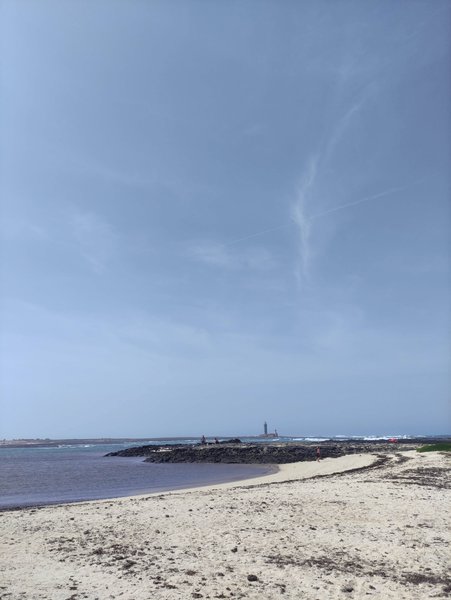 View across the beach and lagoons at Los Charcos with the lighthouse visible on the horizon. — Los Charcos (Fuerteventura), La Oliva, Canary Islands, Spain