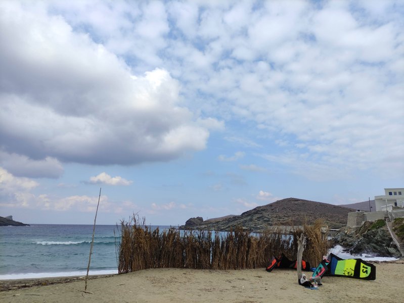 View of the beach at Kolimbithres with kitesurfing equipment on the sand and waves in the bay. — Kolimbithres (Tinos), Κάτω Κλείσμα, South Aegean, Greece
