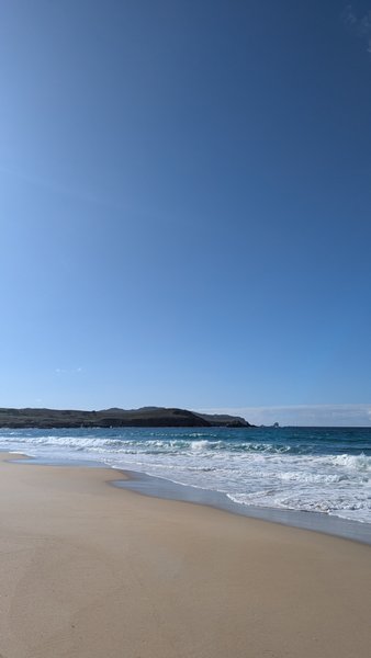 A wide sandy beach with breaking waves under a clear blue sky at Ponzos. — Ponzos (Ferrol), Covarradeiras, Galicia, Spain