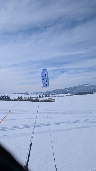A snowkite flying over a vast snowy field with mountains in the background. — Kapliczka Orava, Oravské Veselé, Slovakia