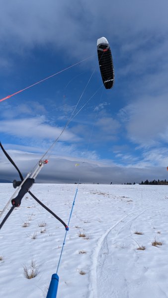A snowkiting kite flies over a snow-covered field. — Kapliczka Orava, Oravské Veselé, Slovakia