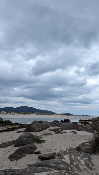 A view of the sandy and rocky shoreline at Playa de Carnota under a cloudy sky. — Praia de Carnota (Carnota), Carnota, Galicia, Spain