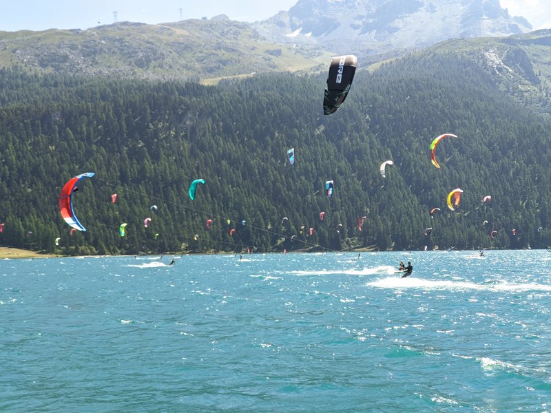 Many kitesurfers enjoy a windy day on Lake Silvaplana with mountains in the background. — Silvaplana (Lake Silvaplana), Silvaplana, Switzerland