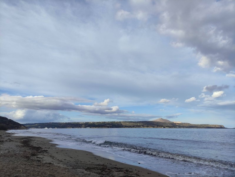 A wide view of the beach and calm water at Kalamion, Greece, with hills in the distance. — Kalamion (Kalyves), Kalyves, Greece