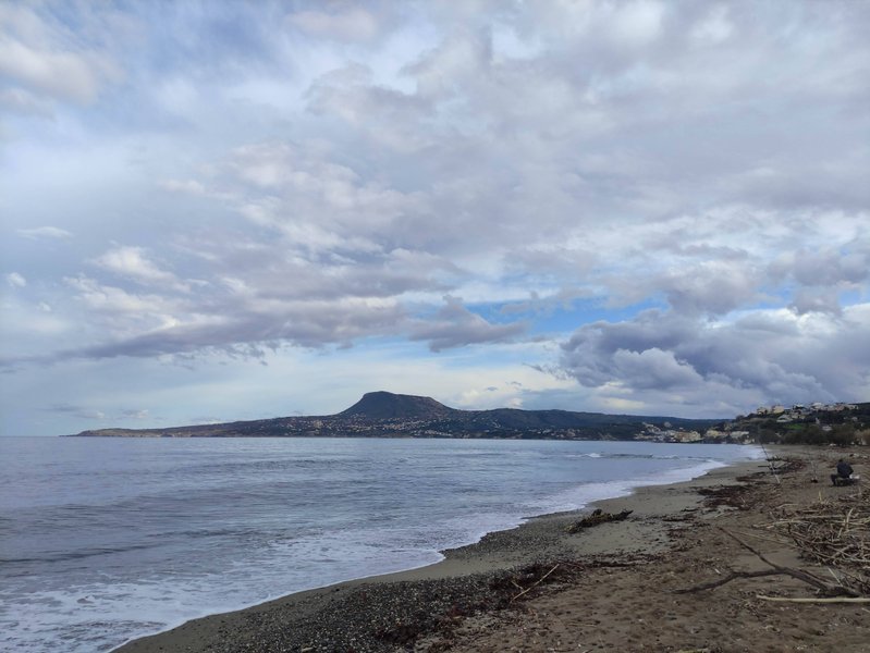 A wide view of the sandy beach and coastline at Kalamion under a cloudy sky. — Kalamion (Kalyves), Kalyves, Greece