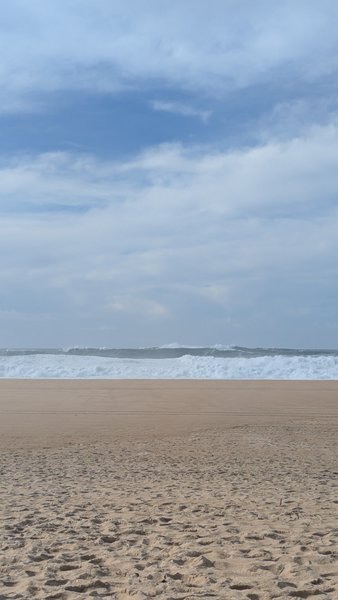 Large waves breaking on the wide sandy expanse of Praia do Norte. — Praia do Norte (North Beach), Nazaré, Portugal