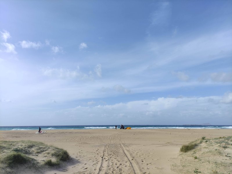 A wide sandy beach at Falasarna with kite surfers visible in the distance under a blue sky. — Falasarna-Riff (Platanos), Platanos, Region of Crete, Greece