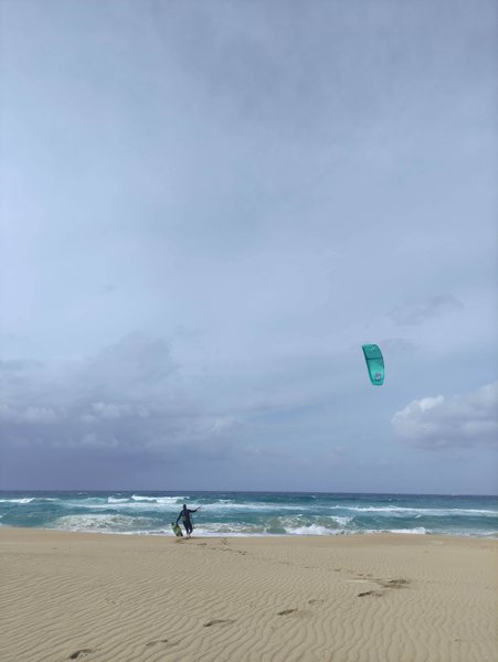 A kitesurfer prepares to launch from the wide sandy beach at Falasarna. — Falasarna-Riff (Platanos), Platanos, Region of Crete, Greece